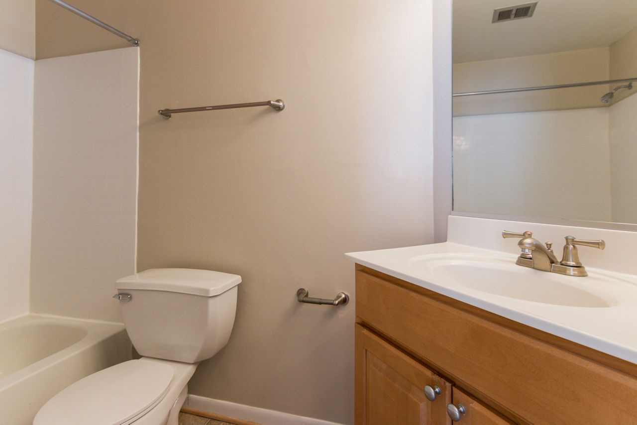 Luxury bathroom with sleek fixtures and granite countertops at Avana Oak Mill Apartments, providing a modern living experience