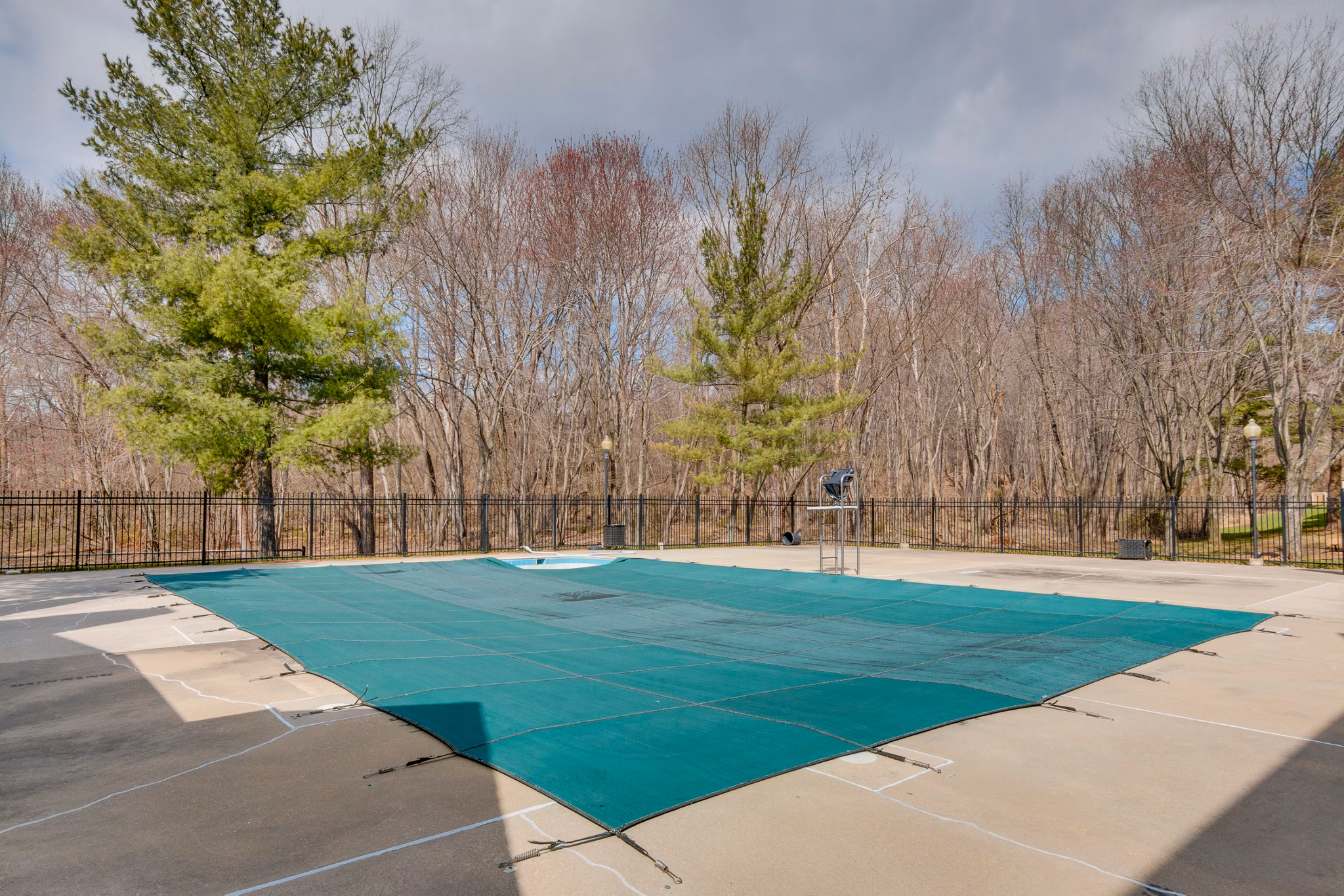 Sparkling outdoor pool at Avana Oak Mill Apartments with comfortable lounge chairs and lush landscaping