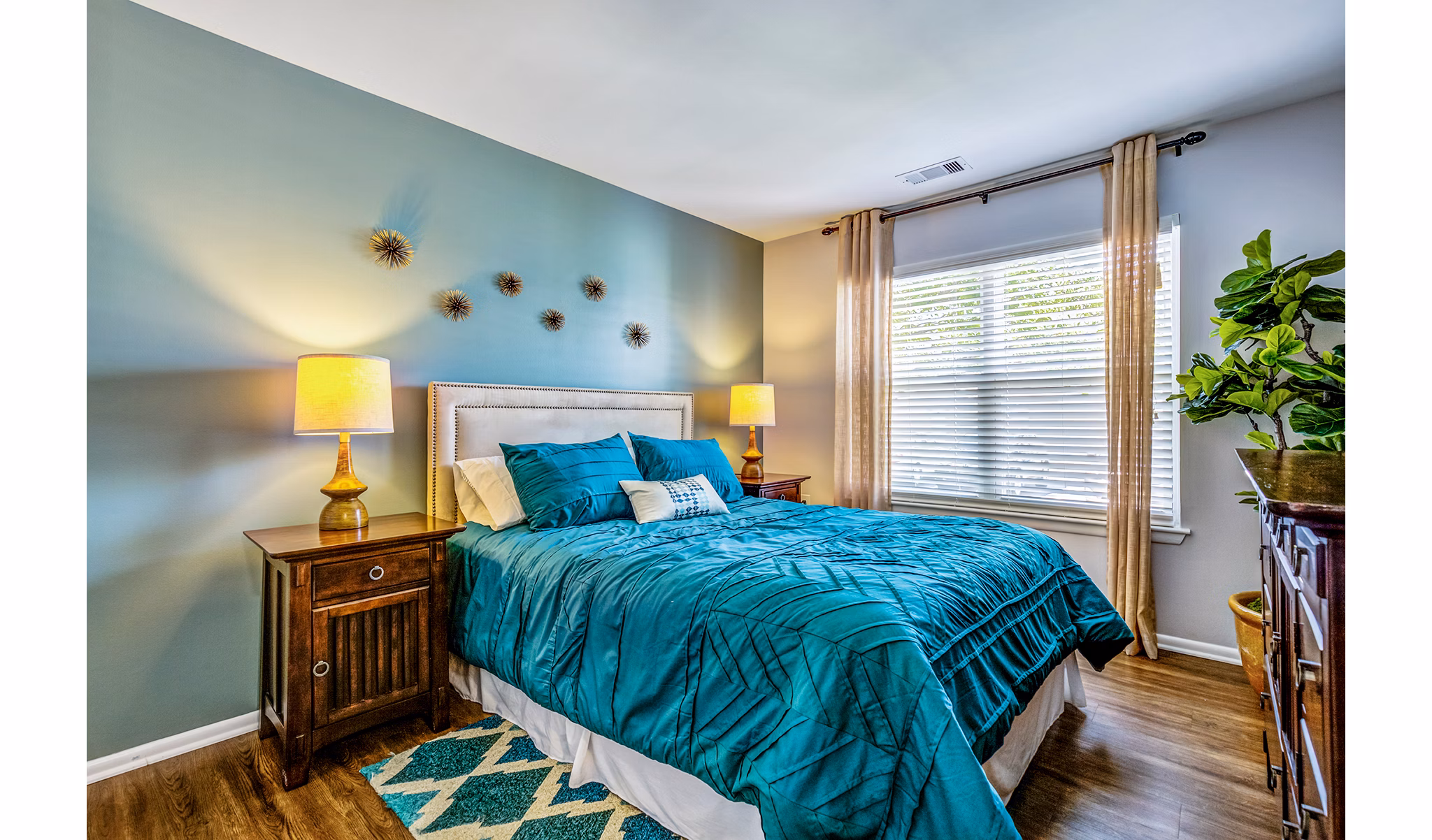 Cozy bedroom with modern decor at Avana Heather Ridge Apartments, featuring a queen-size bed and ample natural light