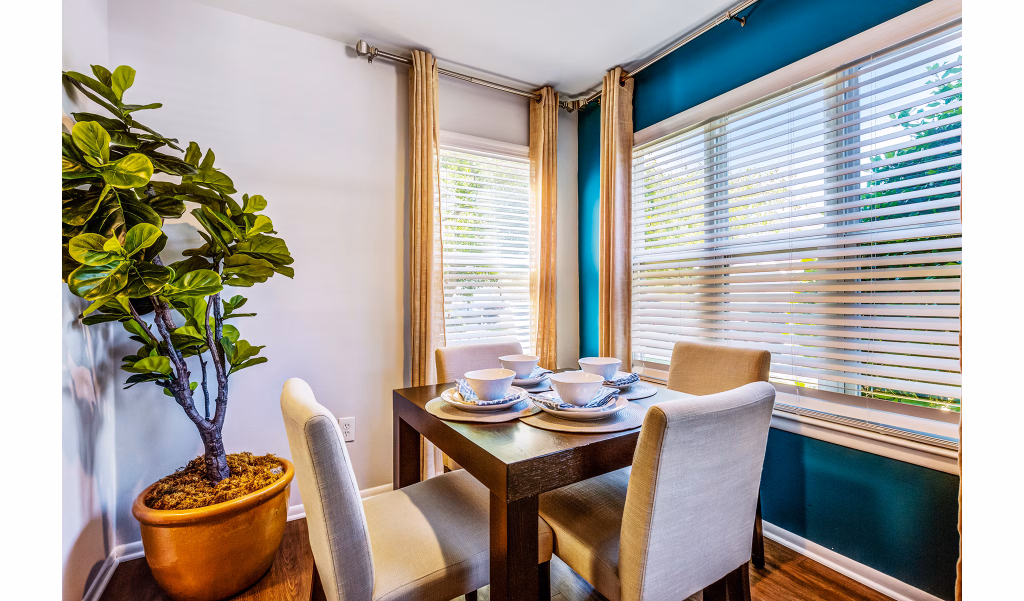 Dining room with elegant wooden table and modern light fixtures at Avana Heather Ridge Apartments