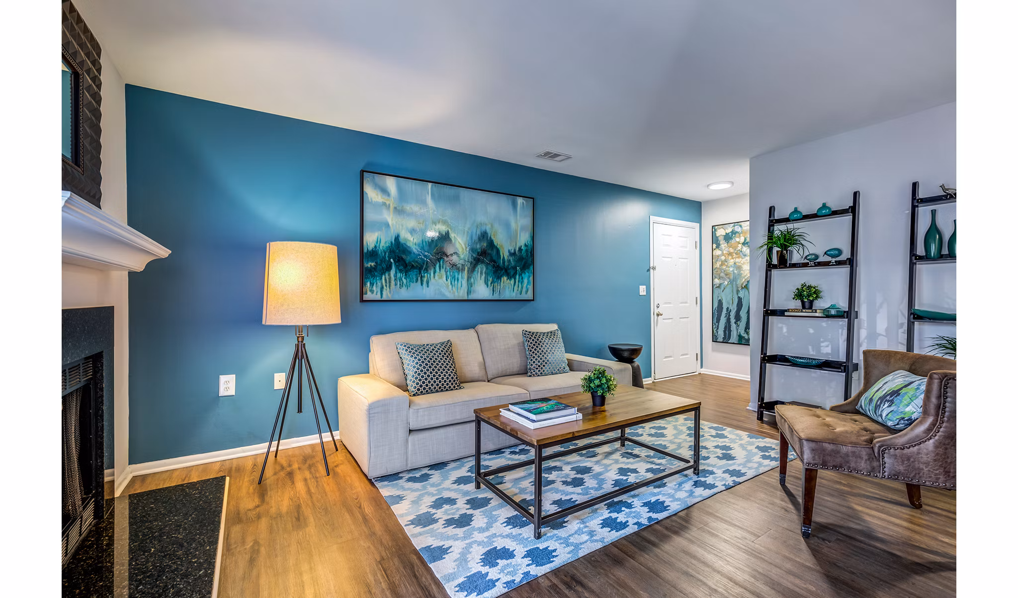 Cozy living room with a modern sofa and large windows at Avana Heather Ridge Apartments