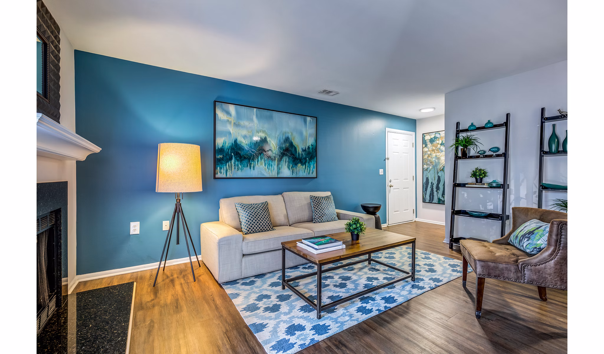 Cozy living room with a modern sofa and large windows at Avana Heather Ridge Apartments