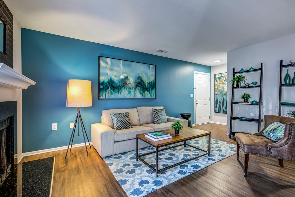 Cozy living room with a modern sofa and large windows at Avana Heather Ridge Apartments