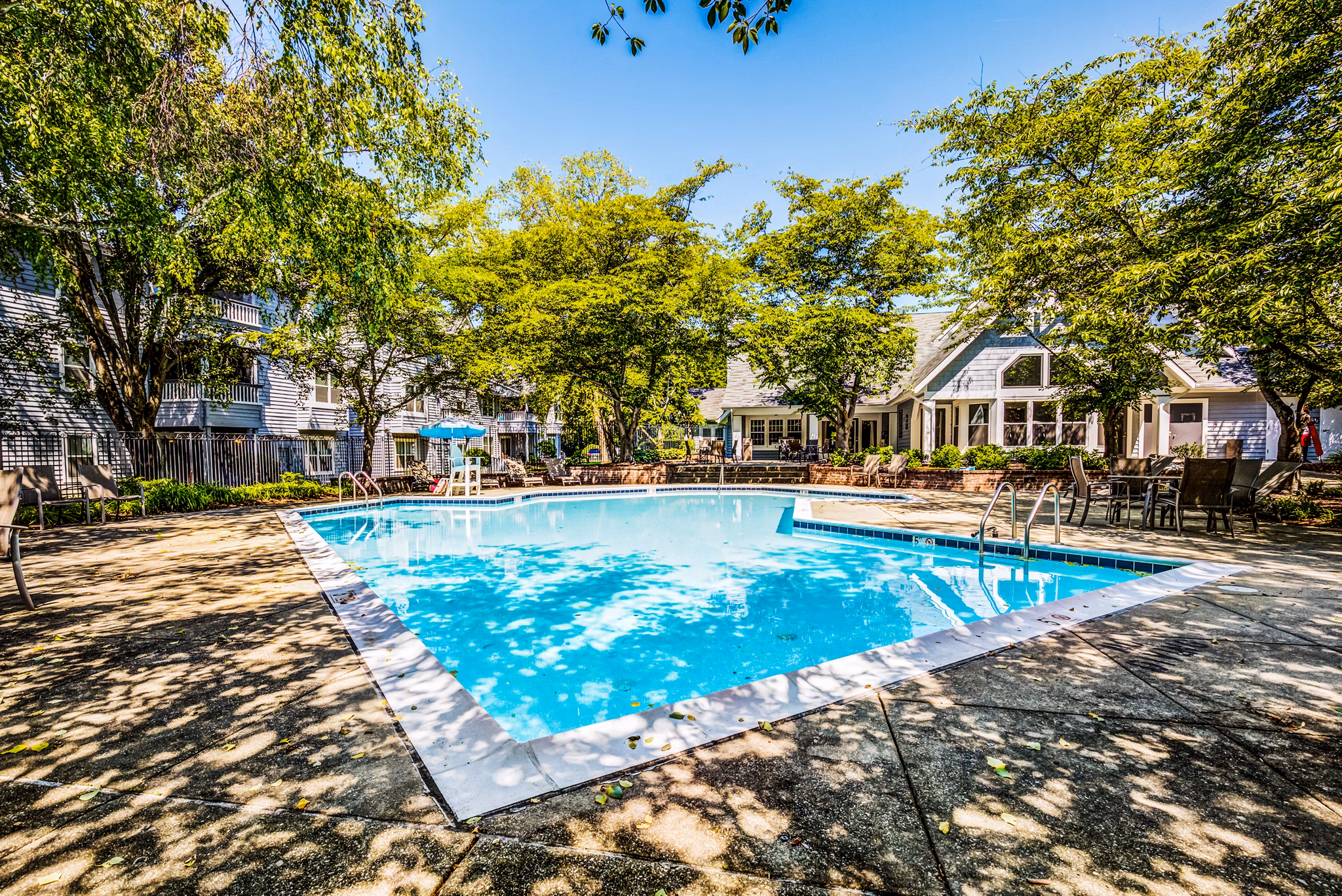 Relaxing poolside area at Avana Heather Ridge Apartments featuring luxury lounge seating and crystal-clear waters