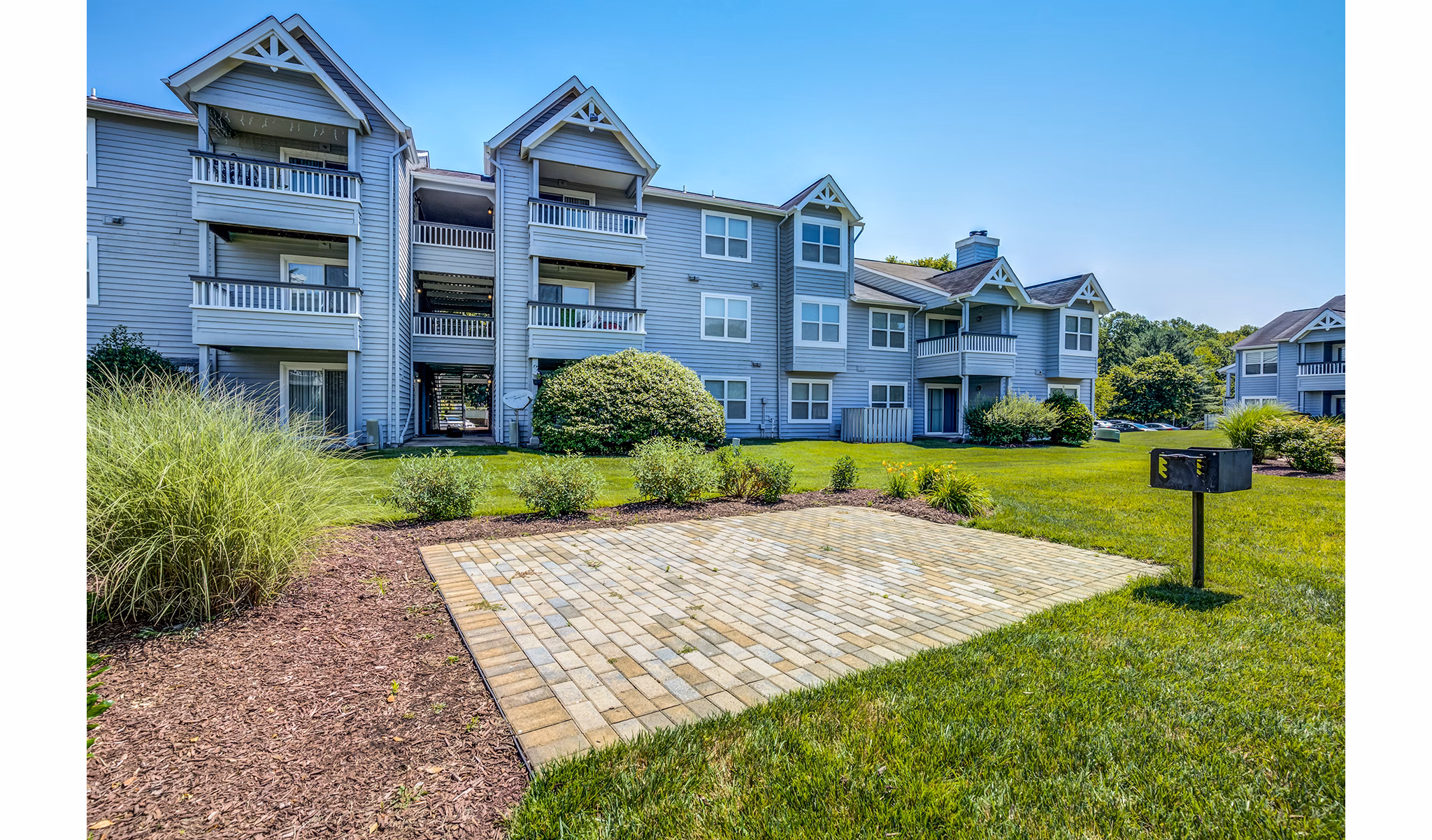 Outdoor courtyard with grilling stations at Avana Heather Ridge Apartments