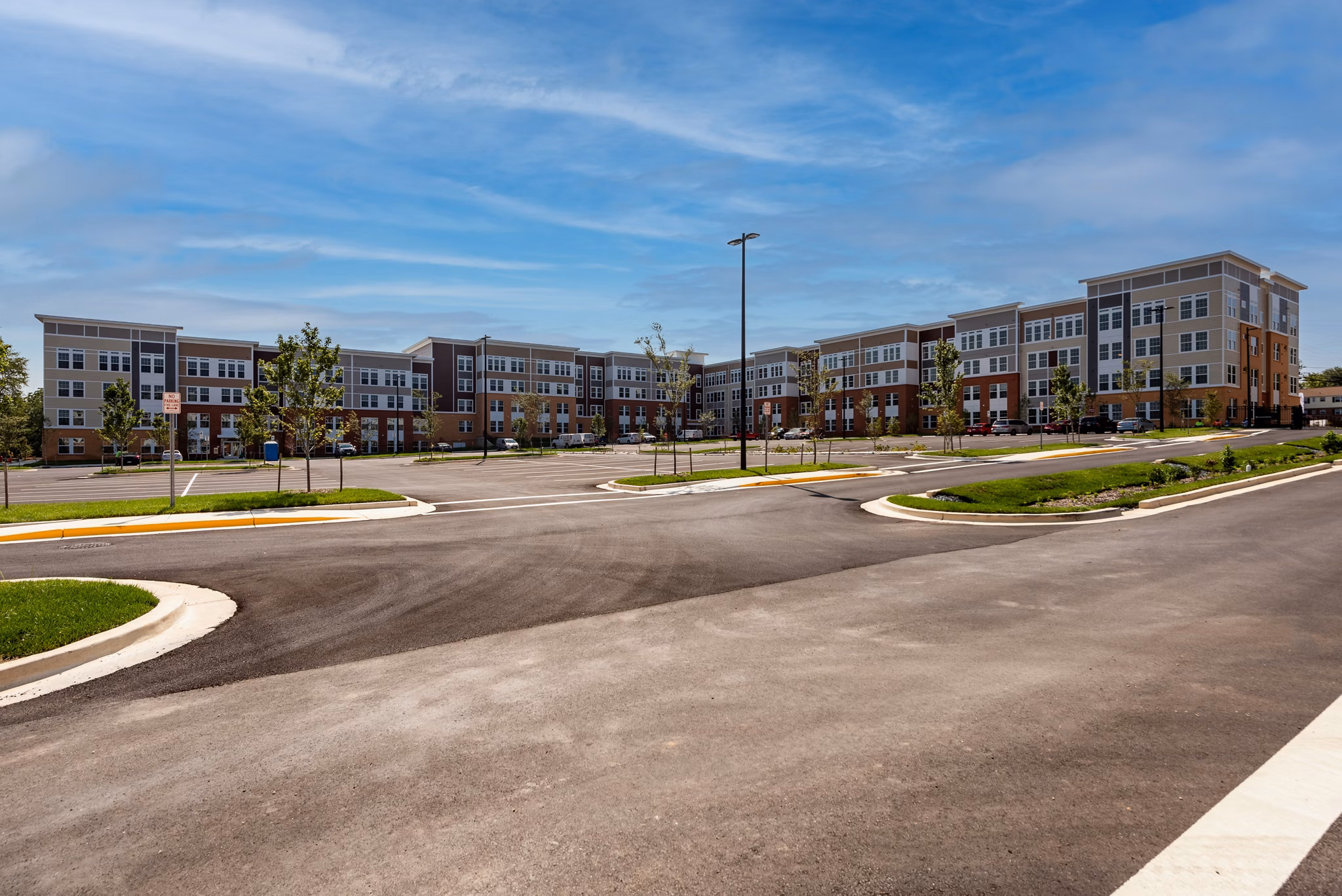 Luxury apartment complex with spacious parking lot in a vibrant community