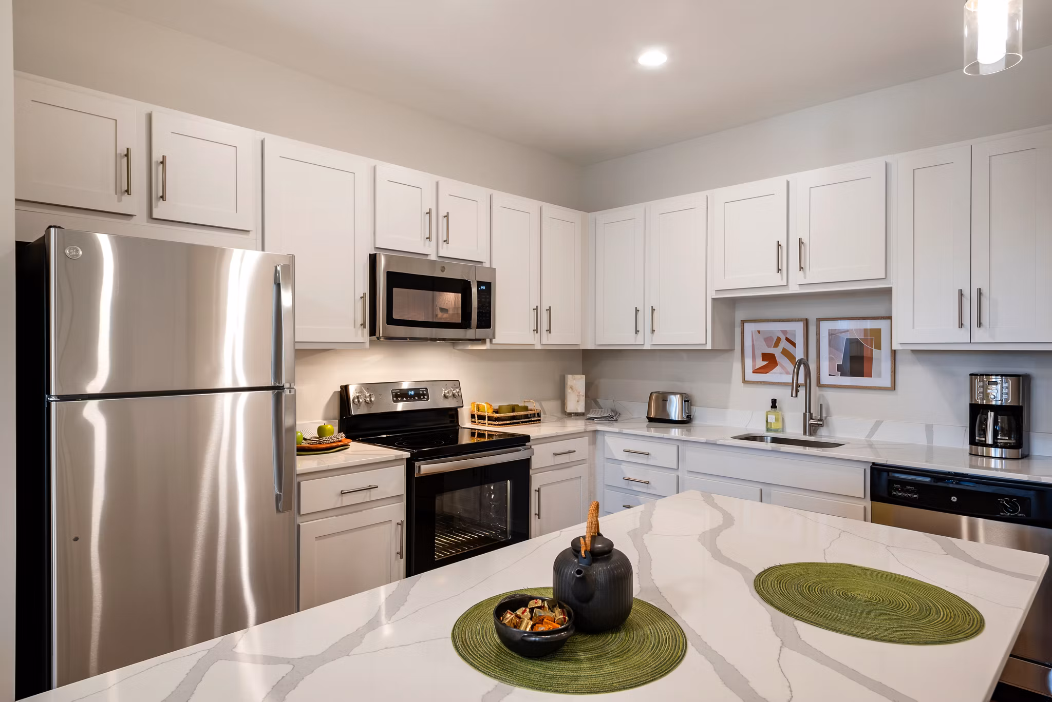 Modern kitchen featuring stainless steel appliances and granite countertops in Addison Row luxury apartments