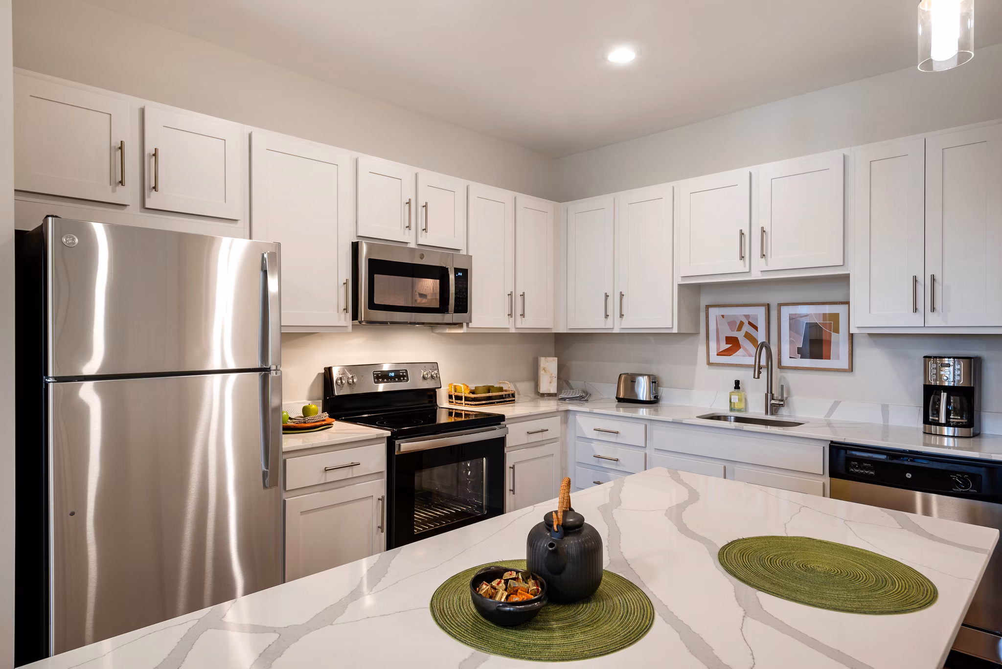 Modern kitchen featuring stainless steel appliances and granite countertops in Addison Row luxury apartments