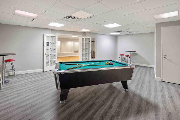 Vibrant game room with pool table and seating at The Luckman Apartments, offering a perfect space for relaxation and entertainment