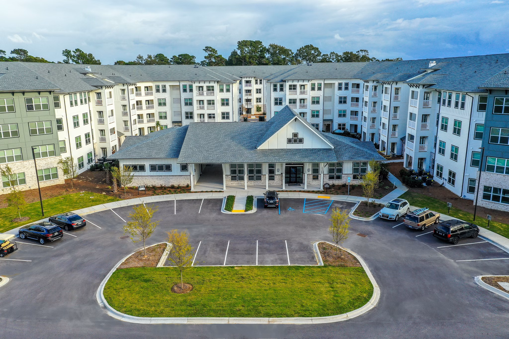 Large residential building with landscaped grounds and parking in a luxury apartment community