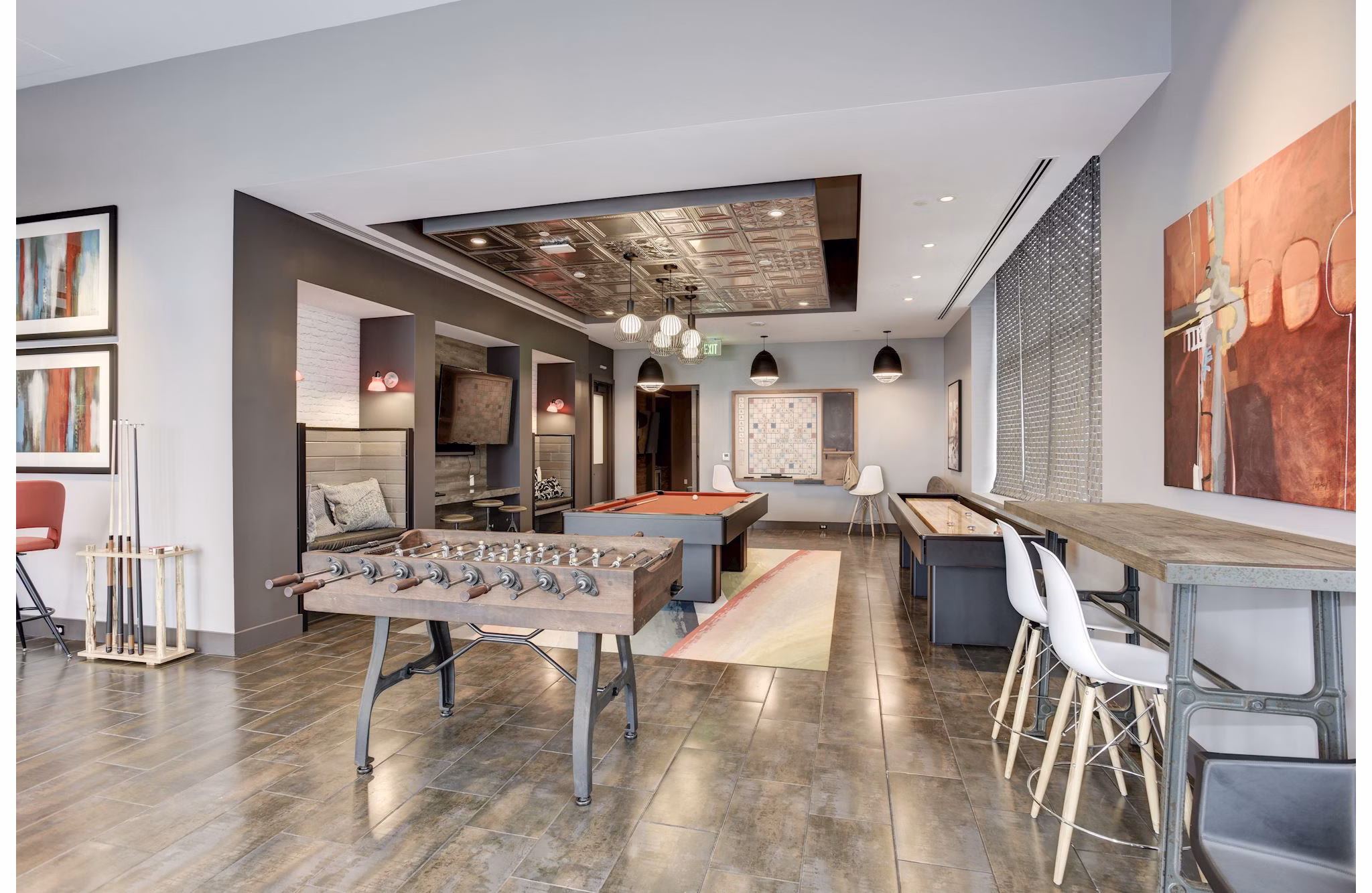 Clubhouse game room with billiards and flat-screen TVs at 225 N Calvert Apartments in Baltimore, Maryland