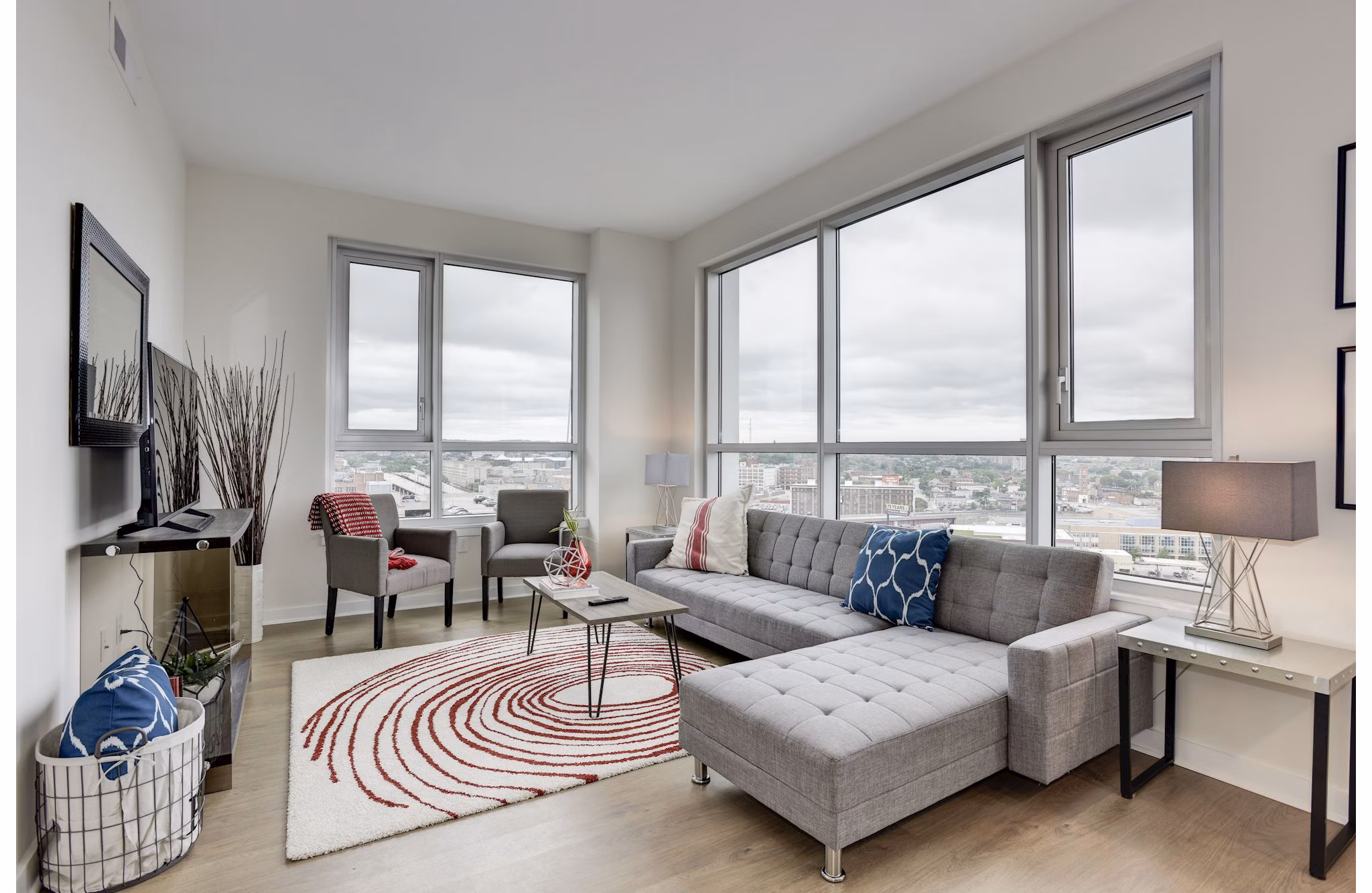 Bright living room with large windows and modern furniture at 225 N Calvert Apartments