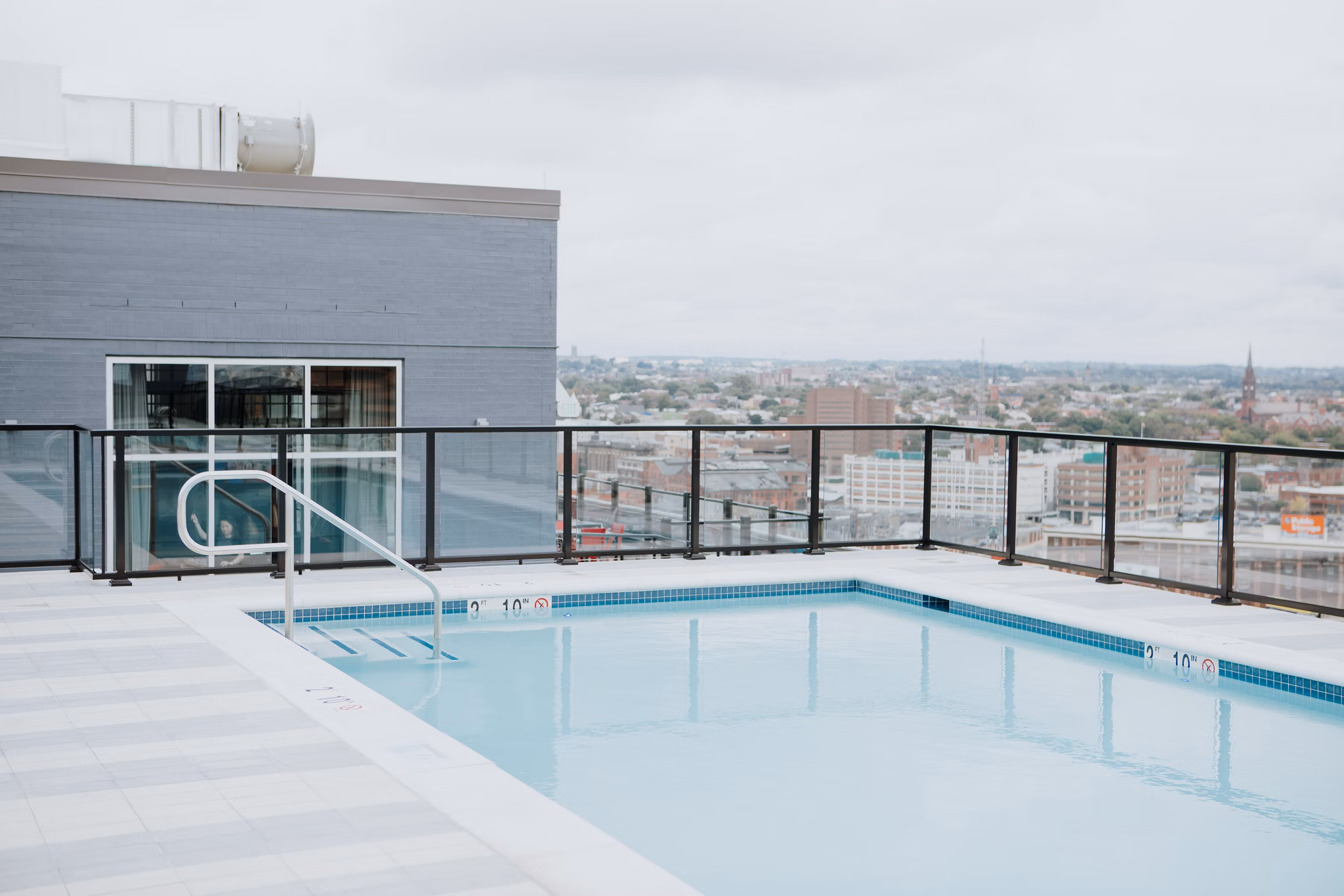 Scenic rooftop pool with lounge seating at 225 N Calvert Apartments