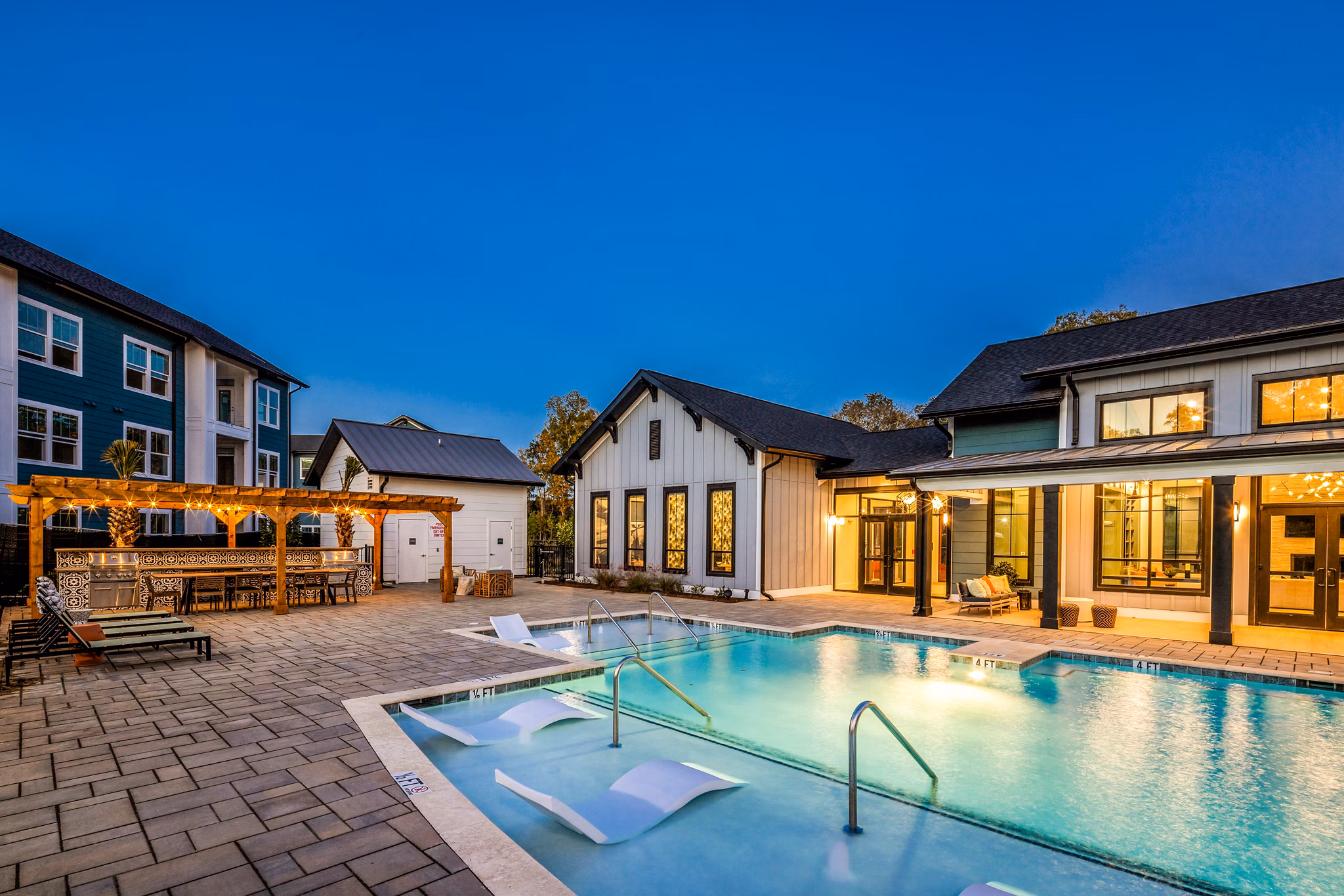Outdoor pool surrounded by lounge chairs at Broadstone Ingleside Apartments, offering luxury amenities and leisure spots for residents
