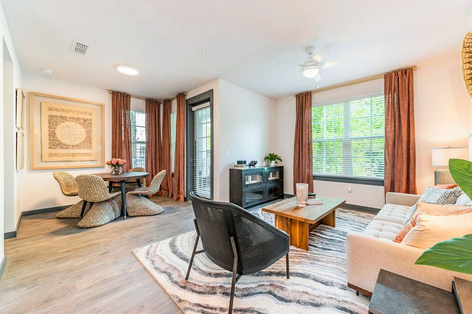 Elegant living room with modern furnishings and large windows at The Reserve at Venice Apartments
