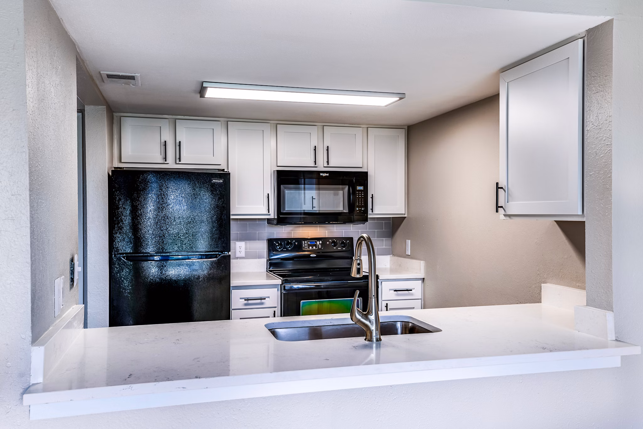 Modern kitchen with stainless steel appliances and granite countertops at Heron Lake Apartments