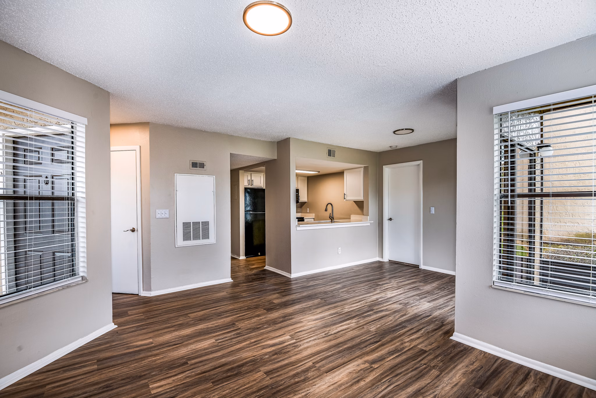 Spacious living room with modern decor and large windows at Heron Lake Apartments