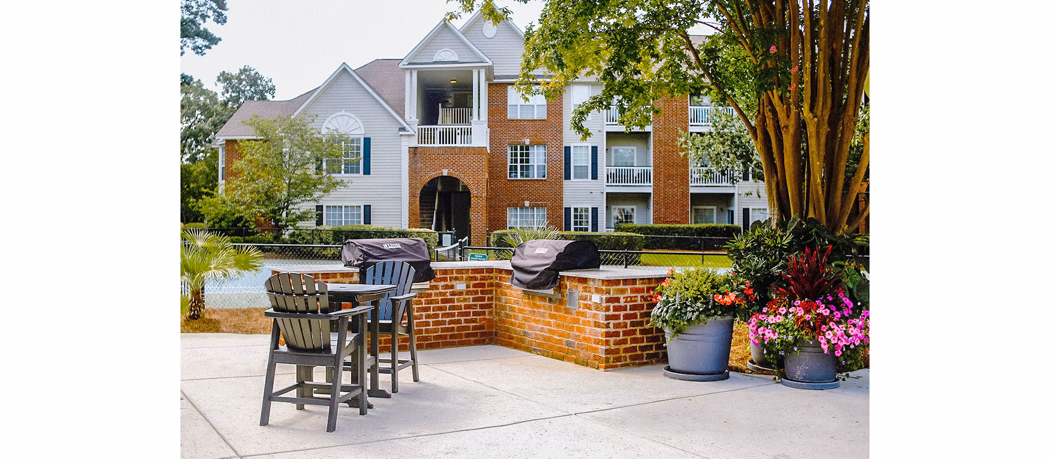 Outdoor grill area with modern seating at 42 Magnolia + 5000 Forest Apartments, ideal for outdoor gatherings and barbecues