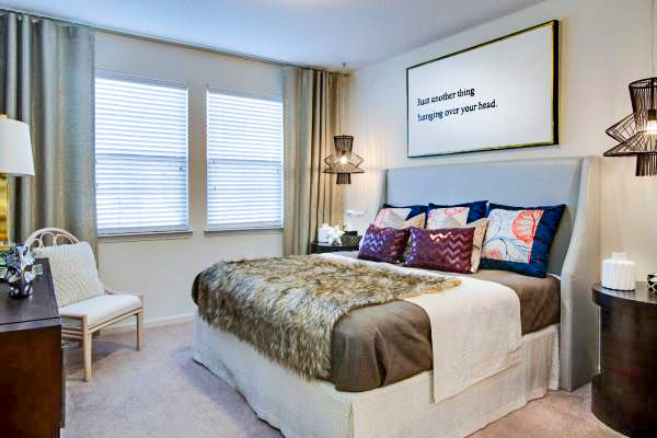 Tapestry at Lake Park Apartments: Elegant bedroom featuring plush bedding and natural light