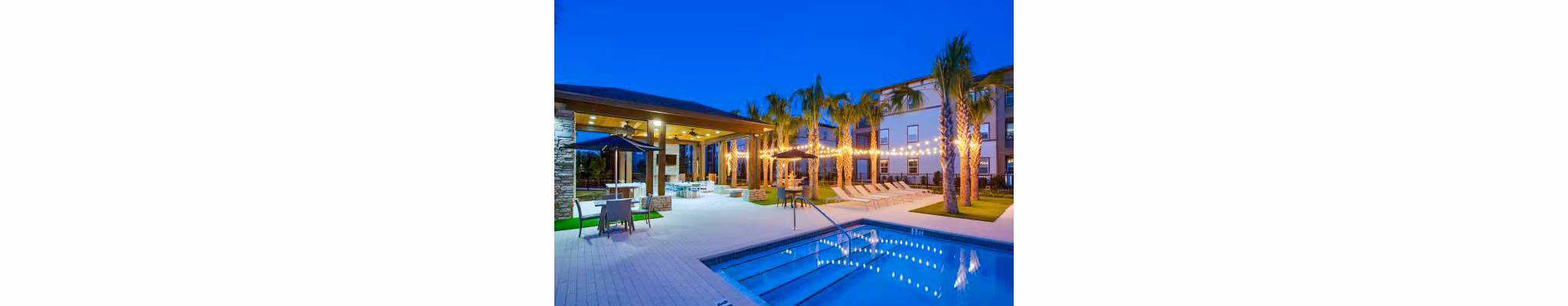 Resort-style pool surrounded by lush landscaping at Tapestry at Lake Park Apartments