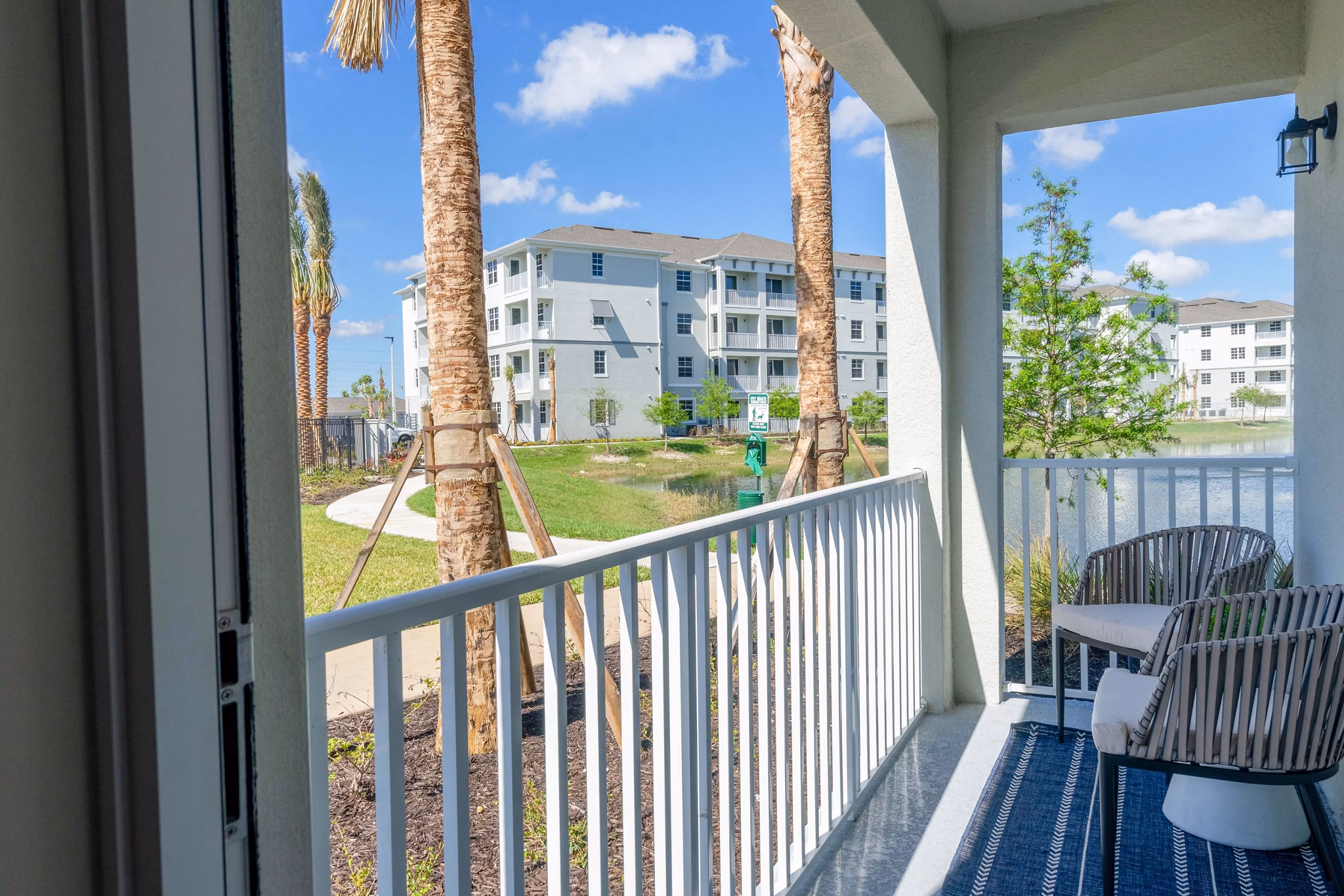 Patio at The Palms at Cape Coral Apartments featuring outdoor seating and lush landscaping, offering a serene relaxation spot