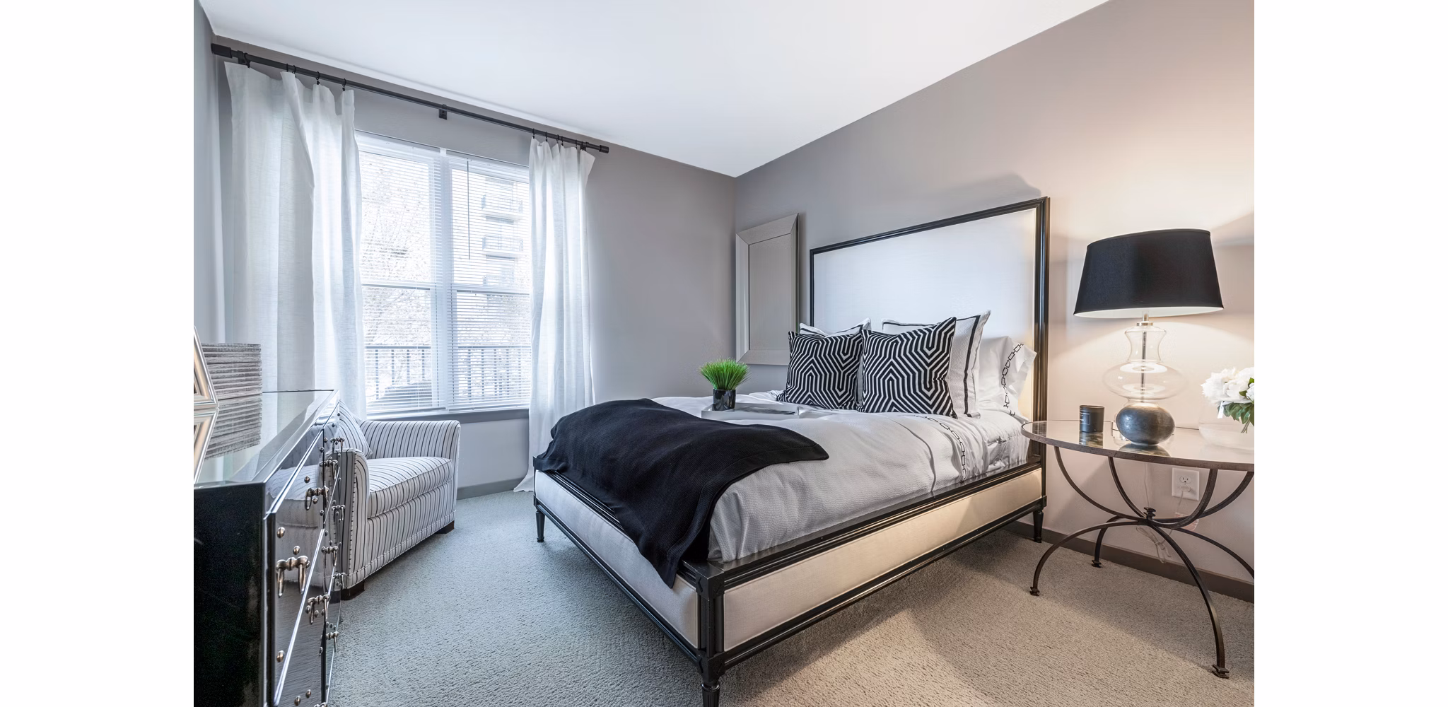 Modern bedroom with plush bedding and large windows at Esplanade at National Harbor Apartments