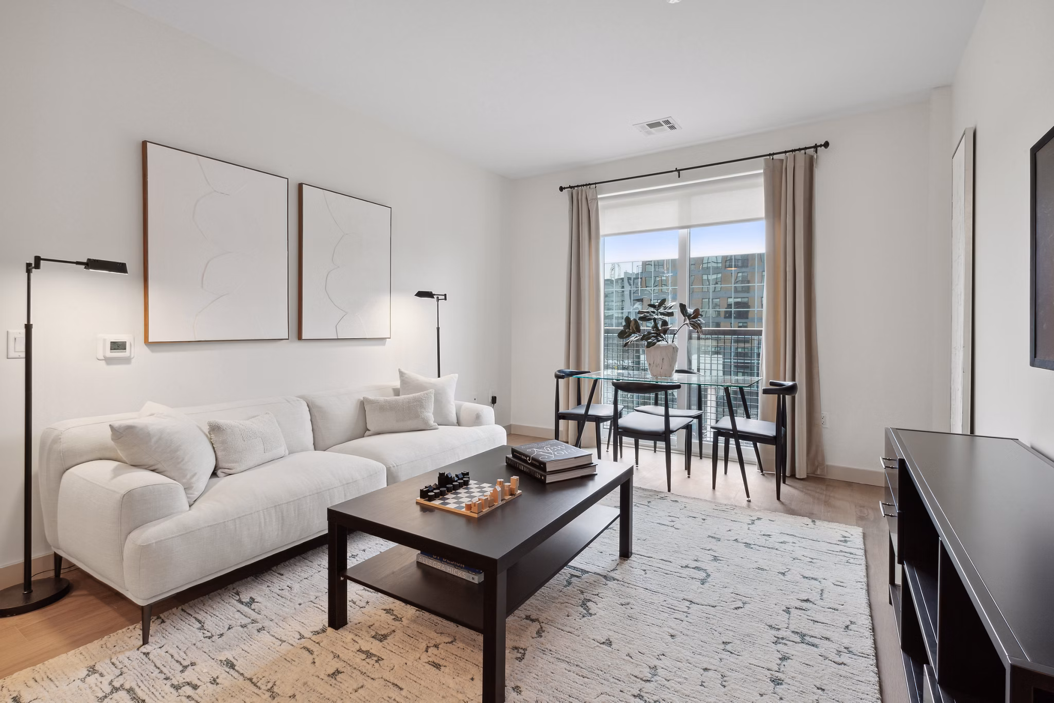 Modern living room with stylish decor and large windows at Motif Apartments: luxury space offering comfort and elegance