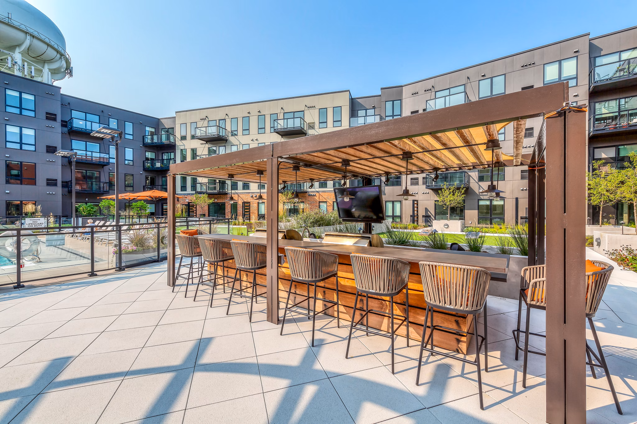 Patio with cozy seating and lush greenery at Avidor Glenview Apartments