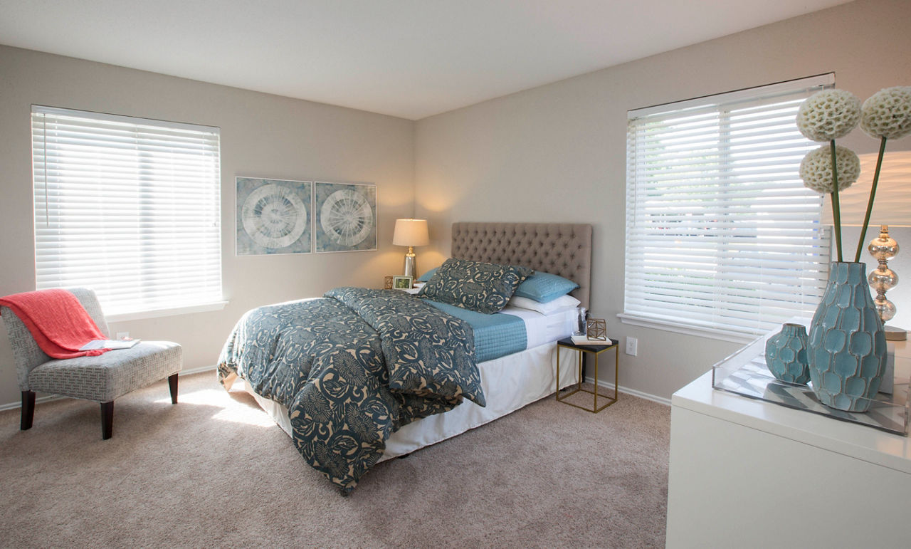 Cozy bedroom with modern decor at Sherwood Crossing apartments, showcasing comfortable living space and ample natural light