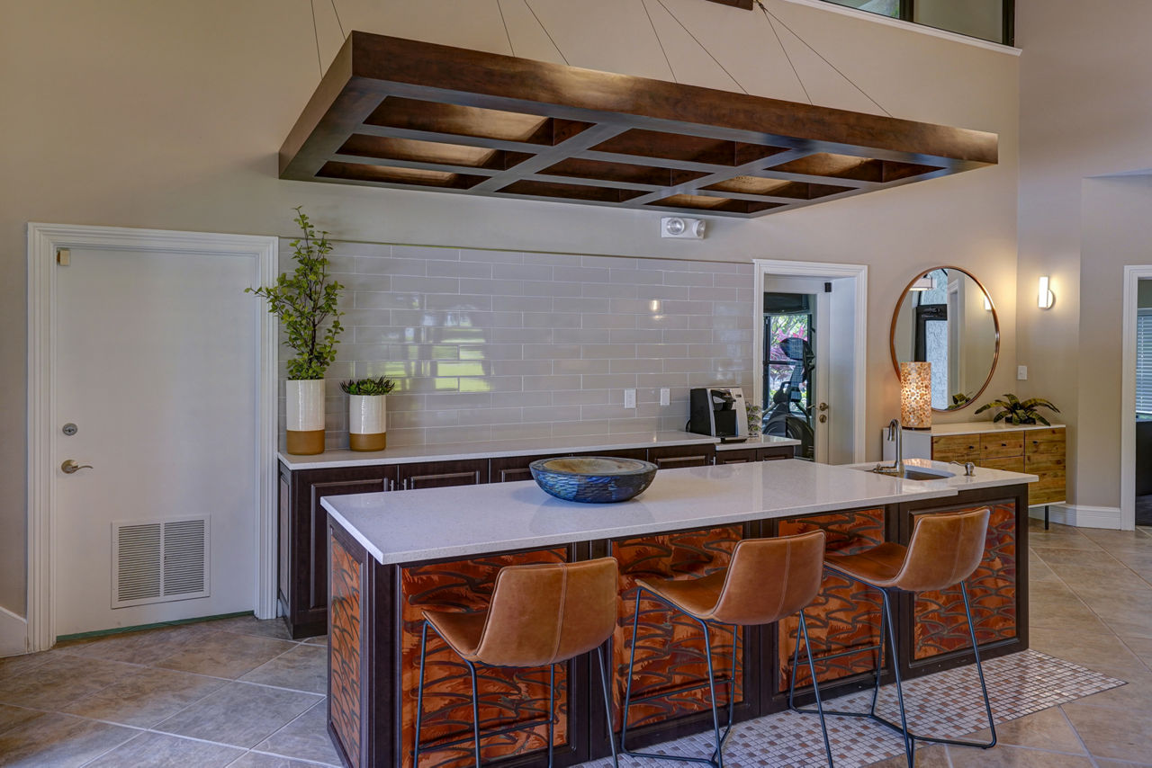 The Plantation Colony: Modern kitchen with island, bar stools, and pendant lighting in luxury Greystar apartments