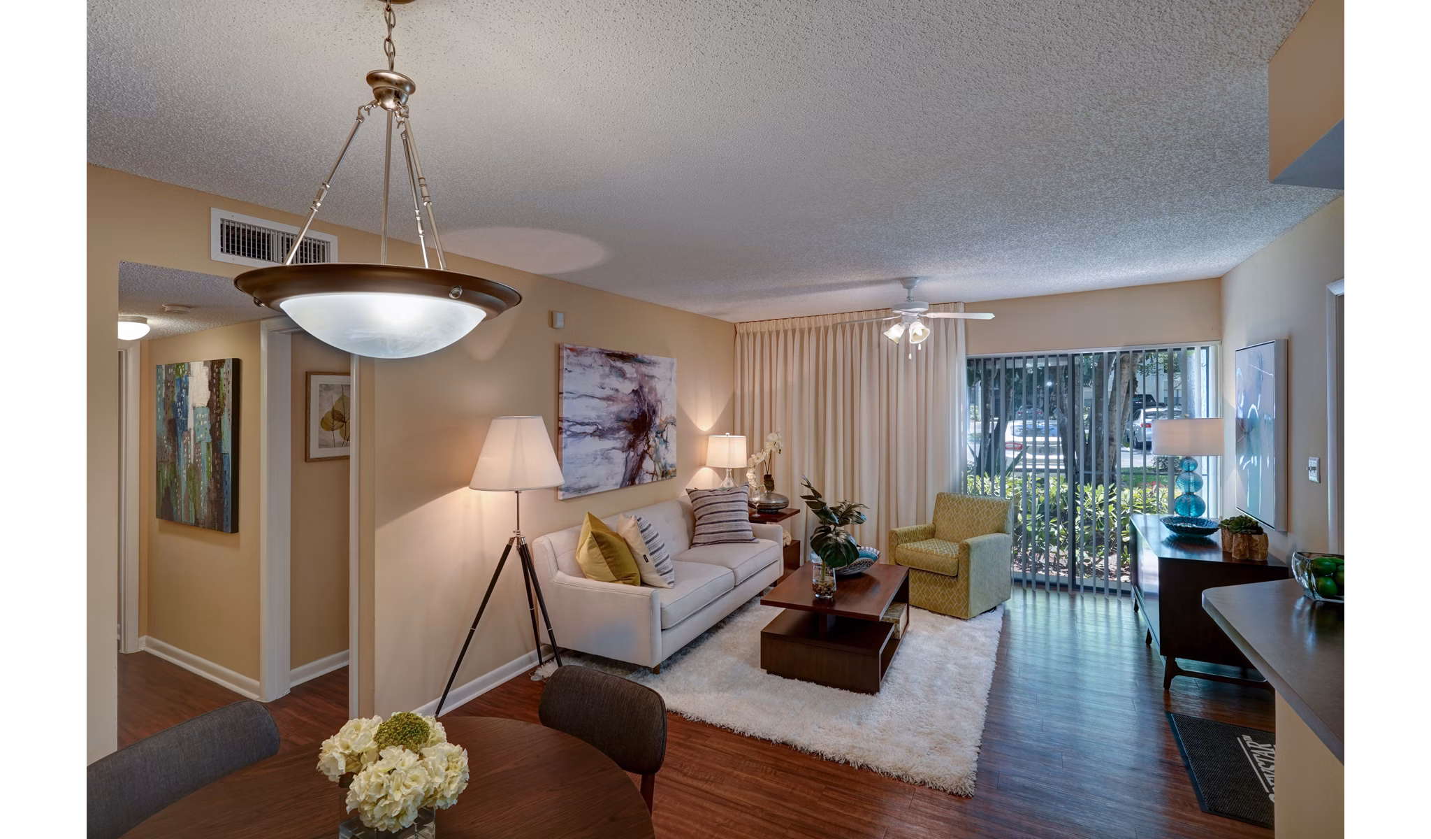 Cozy living room with comfortable seating and a large window at The Plantation Colony Apartments, luxury living in Plantation, Florida