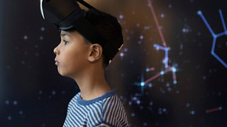 Pensive boy wearing virtual reality simulator glasses looking away
