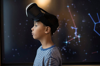 Pensive boy wearing virtual reality simulator glasses looking away