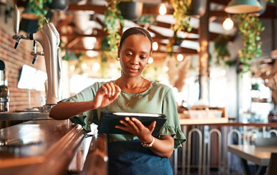 امرأة مع جهاز لوحي في مقهى