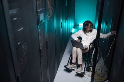 woman in a wheelchair checking on servers
