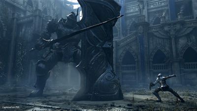 PS5 Demon's Souls screenshot showing the protagonist battling a giant knight monster with large shield.